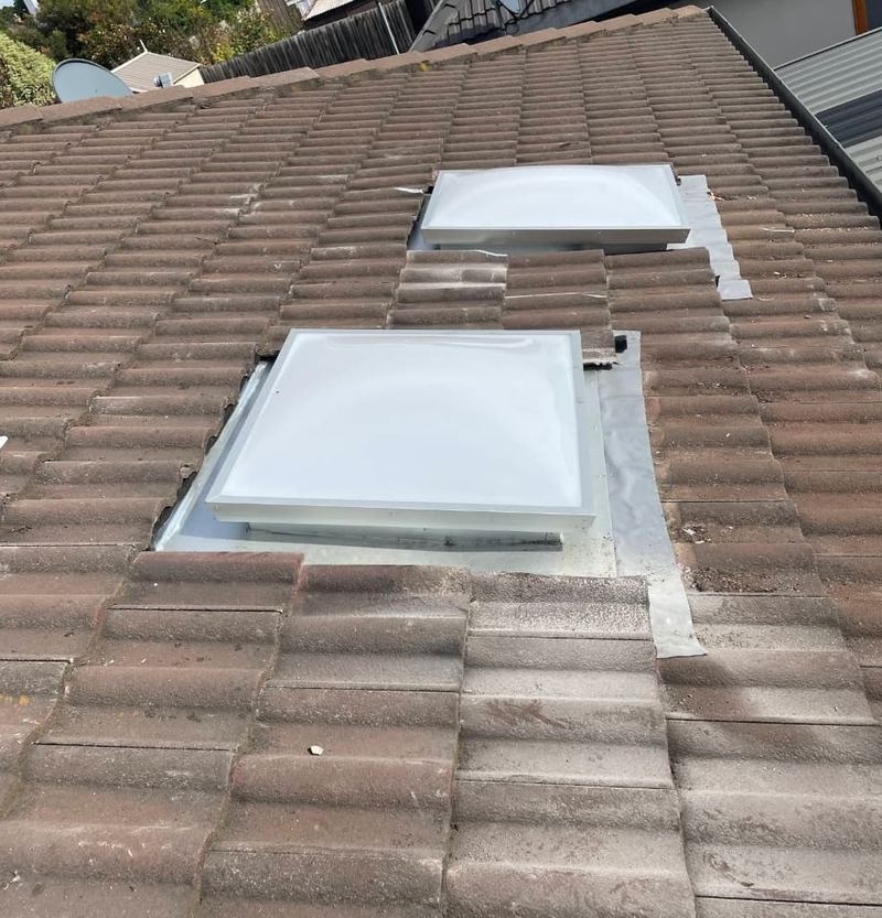 Two skylight replacements on brown tile roof